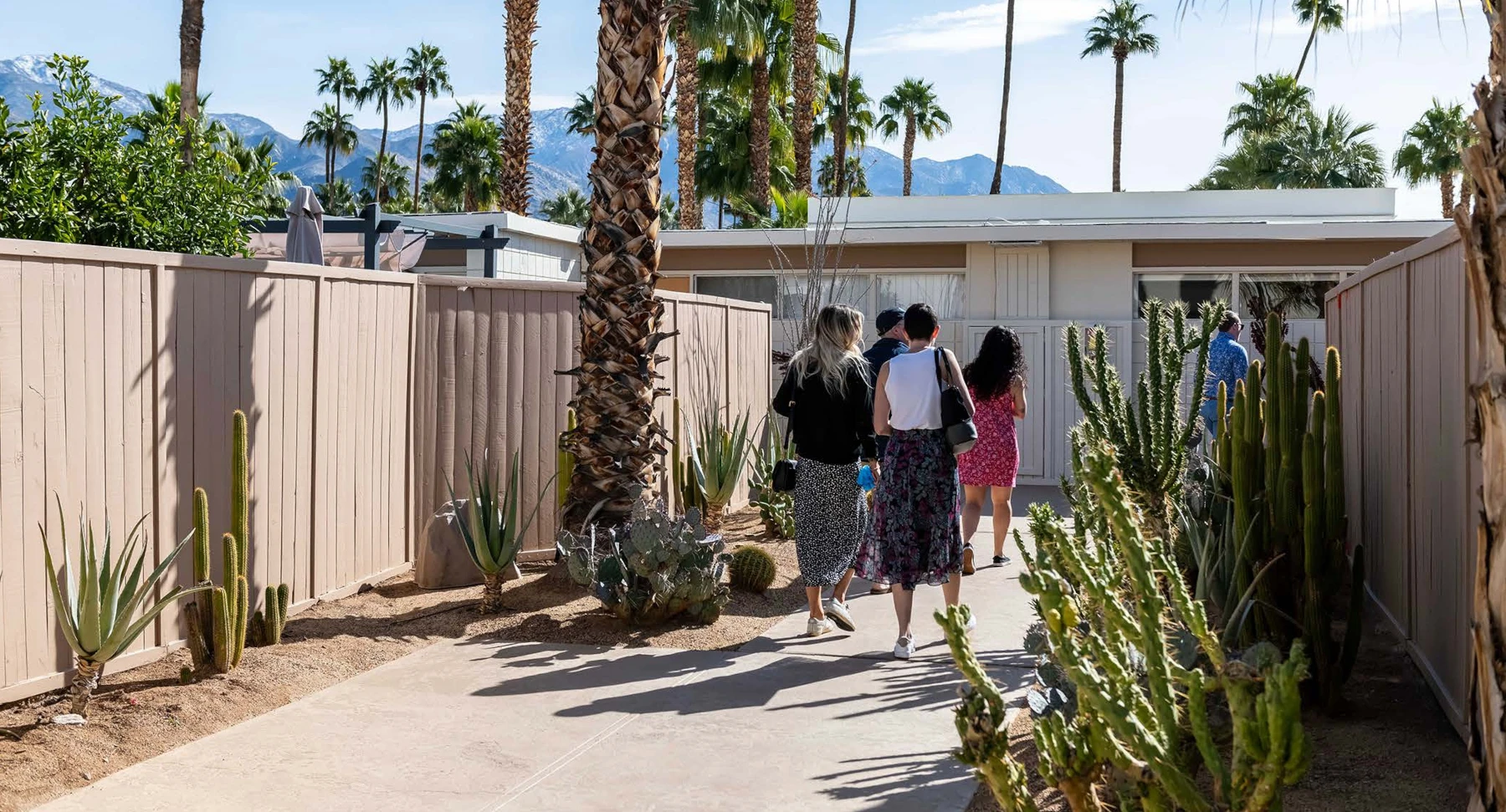 Modernism Week visitors walking up the path to the front door of a Palm Springs modernism home featuring desert landscape