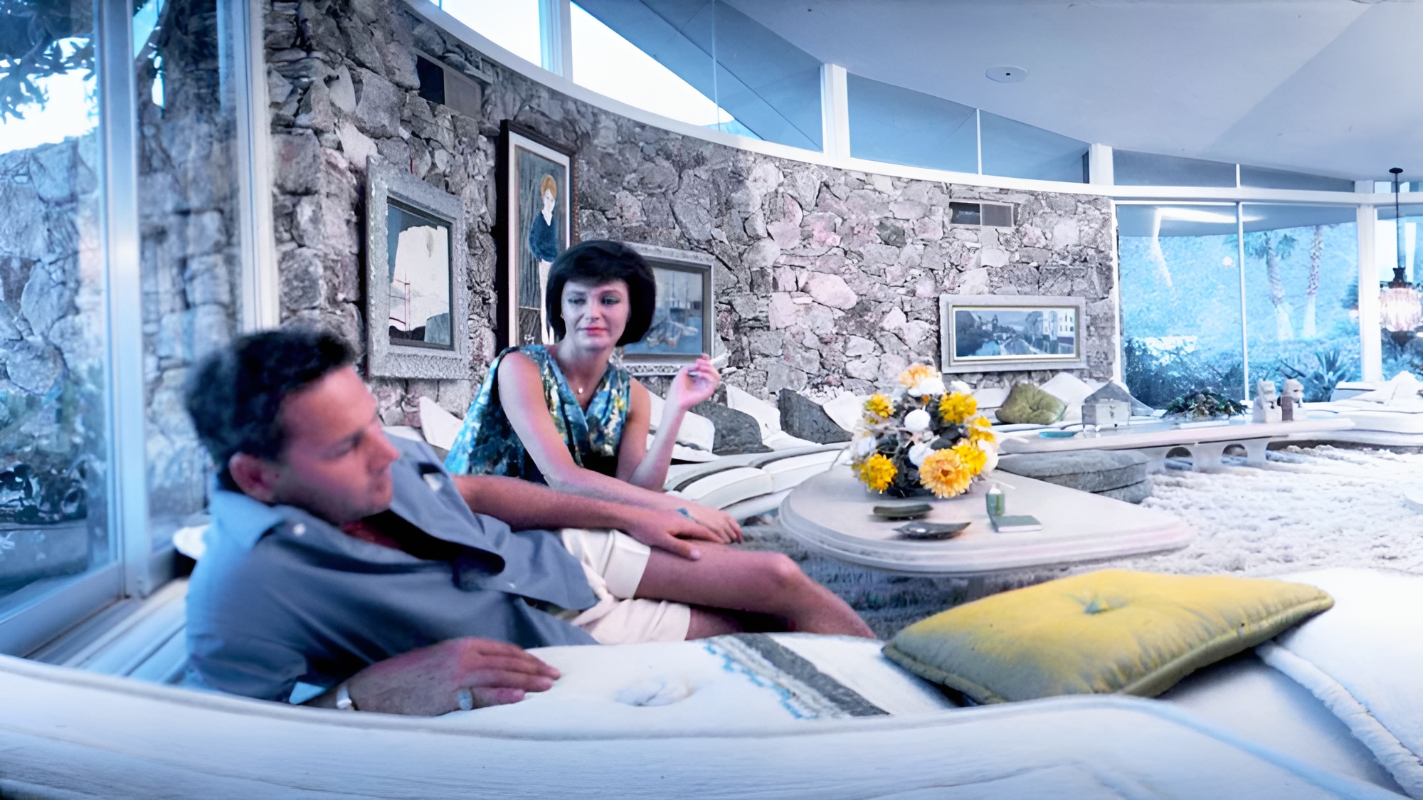 Still frame from the documentary Return to the House of Tomorrow with a midcentury modern interior and a man and woman on a sofa