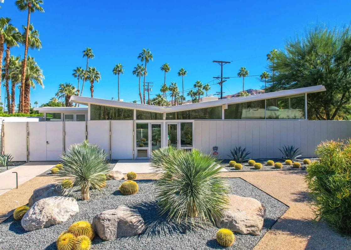 A classic midcentury modern home in Palm Springs with desert landscape front yard and palm trees